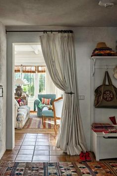 a living room filled with furniture and a fire place next to a window covered in curtains