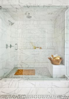 a bathroom with white marble walls and flooring, including a walk - in shower