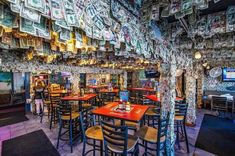 a restaurant with lots of tables and chairs covered in money bills hanging from the ceiling