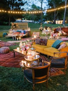 an outdoor seating area is lit up with string lights and decorated furniture for a party