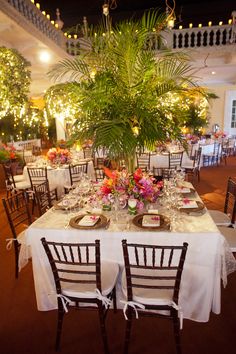 the tables are set with white linens and place settings for formal dinnereons