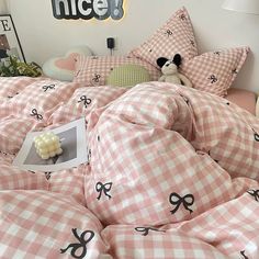 a bed covered in pink and white checkered sheets with black scissors on the covers