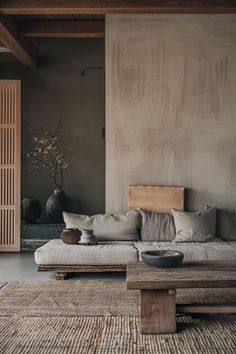 a living room filled with furniture and decor on top of a wooden floor covered in rugs