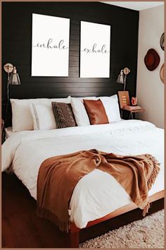 a bed with two pictures on the wall above it and an orange throw rug underneath