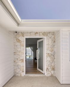 an open door leading into a room with white walls and wood flooring on the outside