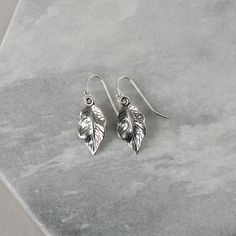 These earrings feature beautifully detailed sterling silver leaves that have a gorgeous shine to them. The leaves are about 17mm long and about 10mm wide with a lovely rippled texture. The earrings dangle a little over an inch from the sterling silver ear wires and are very lightweight and comfortable. The minimalist nature-inspired design of these will make them everyday favourites. More leaf and nature-themed jewelry can be found here: www.etsy.com/ca/shop/juliegarland/search?search_query=natu Silver Leaf-shaped Minimalist Earrings, Sterling Silver Leaf Earrings With Ear Wire, Silver Leaf Minimalist Earrings, Silver Nature-inspired Earrings For Everyday, Silver Nature-inspired Everyday Earrings, Silver Everyday Nature-inspired Earrings, Minimalist Silver Leaf Earrings, Everyday Silver Nature-inspired Earrings, Nickel-free Leaf-shaped Sterling Silver Earrings