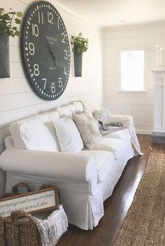 a living room filled with furniture and a large clock on the wall