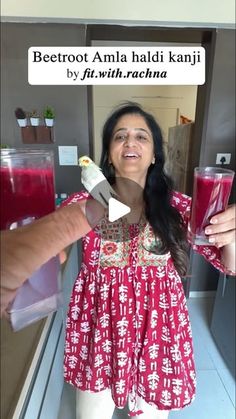 a woman in a red and white dress holding up two glasses with juices on them