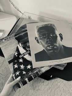 a black and white photo of a person holding an american flag in front of them