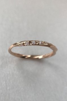 a gold wedding band with five diamonds