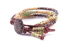 Earthy and elegant. This four-stand beaded leather wrap bracelet boasts a colorful earthy assortment of red-brown Picasso finish, green and canary yellow seed beads, natural brown leather, ad a beautiful antique sun start metal button. Please note: Exact colors may vary due to computer monitors, lighting, and photographic lenses. ©Copyright Via Via Jewelry Designs: All rights reserved. Boho Chic Bracelets, Beaded Leather Wraps, Canary Yellow, Bead Leather, Leather Wrap Bracelet, Natural Brown, Computer Monitors, Leather Wraps, Red Brown