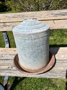 an old metal container sitting on top of a wooden bench