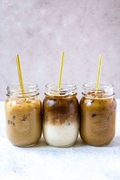 three mason jars filled with ice cream and coffee