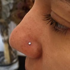 a close up of a person with a nose piercing on their left side of the face