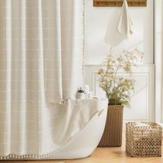 a bath room with a shower curtain and a basket on the floor next to it