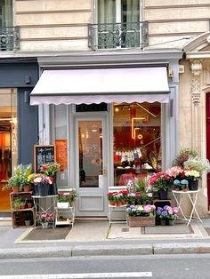 a flower shop with flowers in front of it