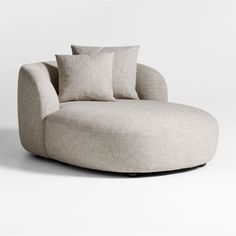 a round couch with three pillows on it