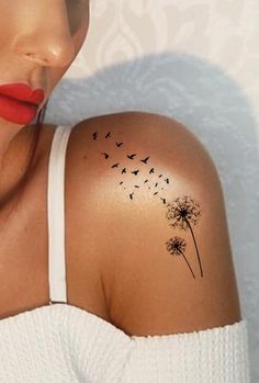 a woman's shoulder with a dandelion tattoo on her left arm and red lipstick