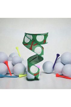 some golf balls and tees on a white table with green wrapping around the top