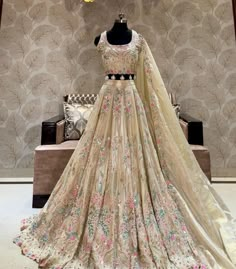 a dress on display in front of a floral wallpapered room with a mannequin