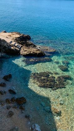 the water is crystal blue and clear with rocks on both sides in front of it