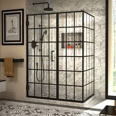 a bathroom with a glass shower door and tile flooring, along with pictures on the wall