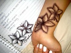 a woman's foot with flowers on it and writing paper in the back ground