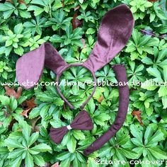 a purple bow and headband laying on top of green leaves