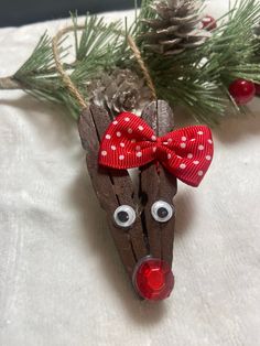 a wooden reindeer ornament with a red bow