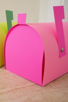 a pink paper mailbox with two green arrows