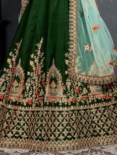 Look gorgeous in this stunning bottle green embroidered silk bridal lehenga choli from Ethnic Plus. This exquisite lehenga set is perfect for women who want to make a statement at their upcoming weddings and special occasions.
The lehenga is made of high-quality taffeta silk material in a beautiful bottle green color. It features intricate zari work, dori work, sequin work, diamond work, and embroidery work, adding a touch of elegance and sophistication. The attention to detail on this lehenga i Green Lehenga With Dori Work, Green Meenakari Saree For Reception, Designer Green Choli With Intricate Embroidery, Green Semi-stitched Meenakari Choli, Green Lehenga With Resham Embroidery For Festivals, Green Raw Silk Lehenga For Reception, Semi-stitched Green Choli For Eid, Designer Green Lehenga For Diwali, Designer Wear Green Lehenga For Diwali