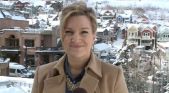 a woman standing in front of a snow covered city