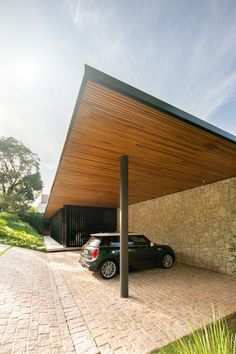 two cars parked in front of a building with a roof over the parking lot area