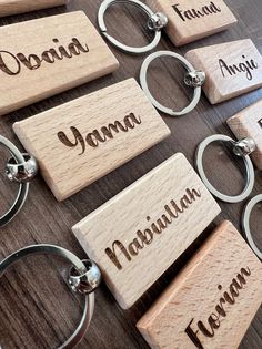 wooden keychains with names on them sitting on a table next to each other