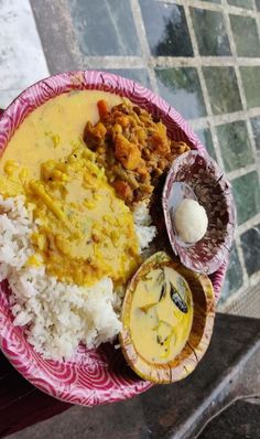 a plate with rice, meat and other food items on it sitting on a table