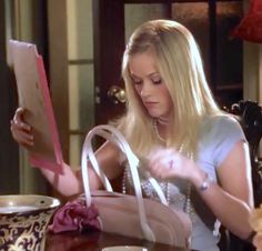 a woman sitting at a table reading a book