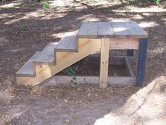 a wooden bench sitting on top of a dirt field