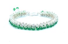 "Take a look at this Swarovski green emerald Bicone tennis bracelet that will enhance any wardrobe. It is made with 4mm Swarovski green bicones, embellished with silver 8/0 and 11/0 Toho seed beads. It has a silver plated lobster claw and chain for closure and measures 7\"." Green Beaded Jubilee Bracelet, Green Faceted Beads Bangle Bracelet, Green Bangle Bracelet With Faceted Beads, Green Crystal Round Bracelets, Green Beaded Bangle Crystal Bracelet, Green Crystal Beaded Bracelets With Round Beads, Green Beaded Crystal Bangle Bracelet, Green Crystal Round Beads Bracelets, Green Crystal Jubilee Bracelet Gift