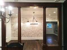 a chandelier hanging from the ceiling in a room with brick walls and wood floors