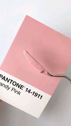 a pair of pink scissors sitting on top of a piece of paper with the word pantone printed on it