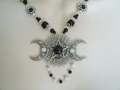 "This beautiful necklace has a black obsidian stone, moonstone settings, pewter silver pentacle, sterling silver plated triple moon pendant, moonstone beads, black obsidian beads, seed beads, pewter silver bead caps, pewter silver filigree connectors and metal chain. 18\" long. Sterling silver plated toggle clasp." Black Moon Phase Necklaces For Festival, Black Moon Phase Necklace For Festival, Gothic Adjustable Necklace With Moon Charm, Black Moon Charm Jewelry For Festivals, Spiritual Black Necklace With Moon Charm, Black Moon Phase Jewelry For Festivals, Mystical Black Round Necklace, Mystical Nickel-free Black Jewelry, Black Jewelry With Moon Charm For Festivals