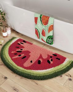 a watermelon rug on the floor next to a bathtub