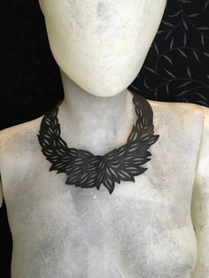 A black leather choker necklace is a close-fitting necklace, typically sitting snugly around the neck. Made from black leather, this particular choker stands out due to its laser-cut design, which boasts shapes reminiscent of leaves. The precision of the laser cut ensures that each shape is distinct and finely detailed, giving the necklace a unique and intricate appearance. Adding a touch of practicality to its elegance, the choker is secured at the back with a metal snap button, allowing for ea Laser Cut Necklace, Large Pearl Necklace, Black Leather Choker, Goth Choker, Leather Choker Necklace, Pearl Necklace Vintage, Laser Cut Earrings, Womens Chokers, Wooden Necklace