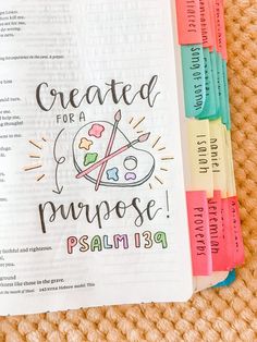 an open bible with the words created for a purpose written on it and colored markers