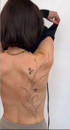 the back of a woman's body with tattoos on her upper and lower back