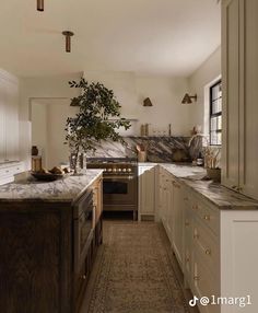 a kitchen with marble counter tops and white cabinets, along with an area rug on the floor