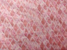 a pink and white area rug with diamond shapes