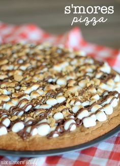 a chocolate and marshmallow pizza sitting on top of a red checkered table cloth