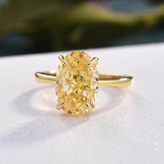 a yellow diamond ring sitting on top of a table