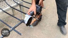 a man is using a circular saw to cut metal bars on a park bench,